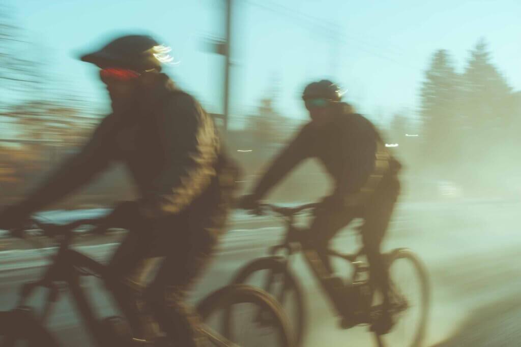 Två personer cyklar snabbt genom staden